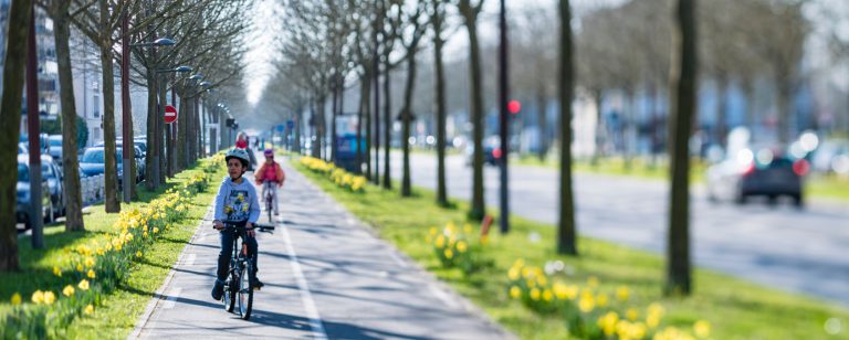 Des personnes sur des vélos sillonnent une piste cyclable du centre ville de Bussy Saint-Georges