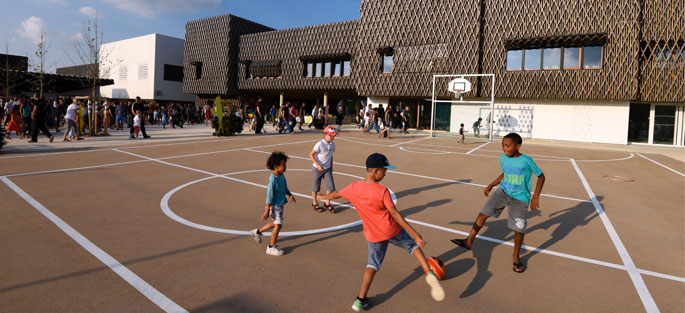 Collégiens jouant au football dans la cour de l'école Louis de Vion dans l'écoquartier de Montévrain (Bâtiment ENR PASSIF)