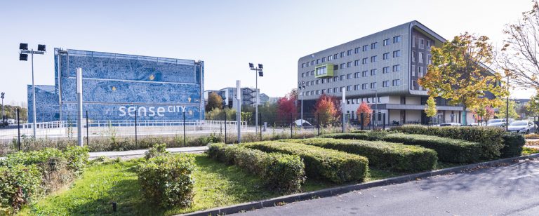 Photographie prise au sol, aux abords de l'Ecole des Ponts ParisTech, bâtiment Corolis (ENR+) et de l'Equipex Sense-City, sur le campus de la Cité Descartes